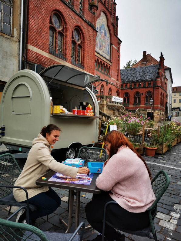 Gemütliches Spielen vorm Cafe-Anhänger